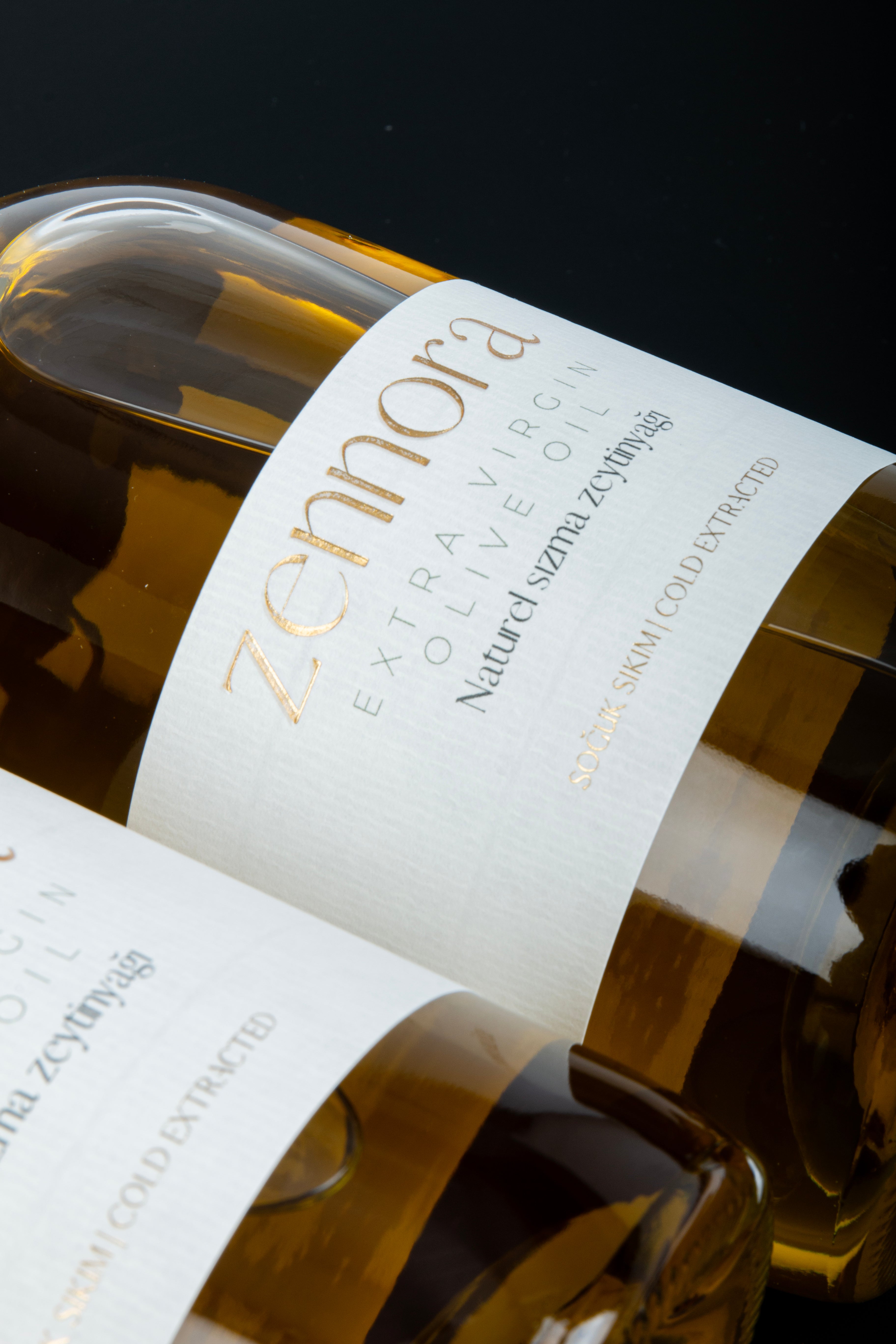 Close-up Zennora extra virgin olive oil bottle with a label on a black background